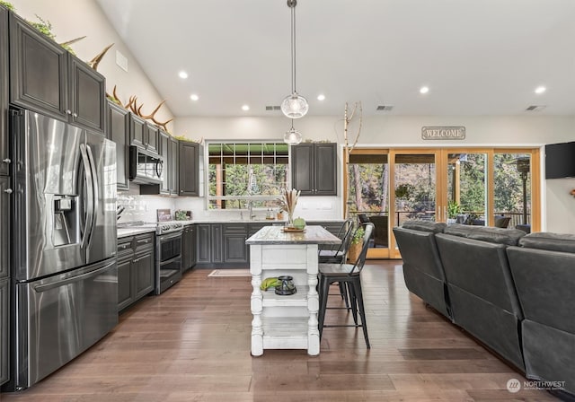 kitchen with appliances with stainless steel finishes, hardwood / wood-style flooring, and a wealth of natural light