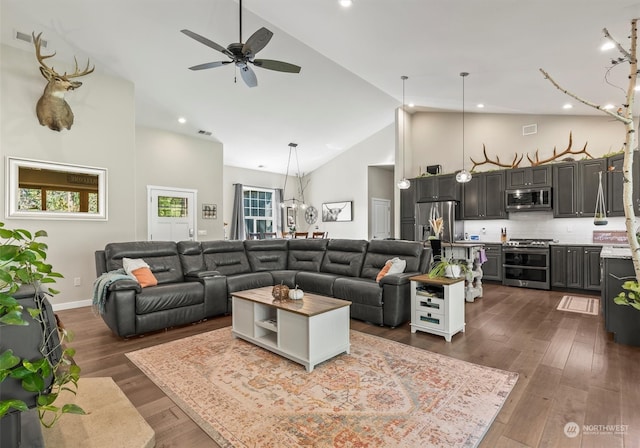 living room featuring ceiling fan with notable chandelier, high vaulted ceiling, and dark hardwood / wood-style floors