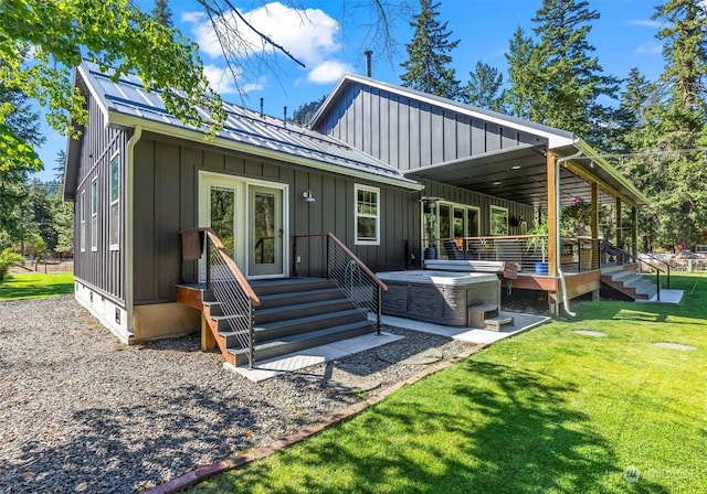 rear view of house featuring a lawn and a deck