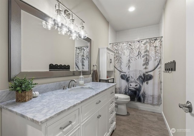 full bathroom featuring hardwood / wood-style floors, vanity, toilet, and shower / bath combo with shower curtain