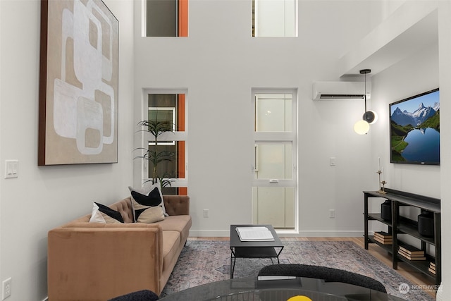 living room with a wall mounted air conditioner and light hardwood / wood-style flooring