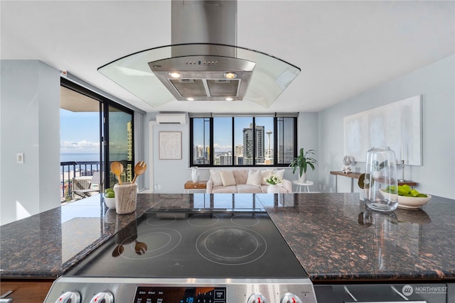 kitchen featuring an AC wall unit, dark stone countertops, hardwood / wood-style floors, black range, and a water view