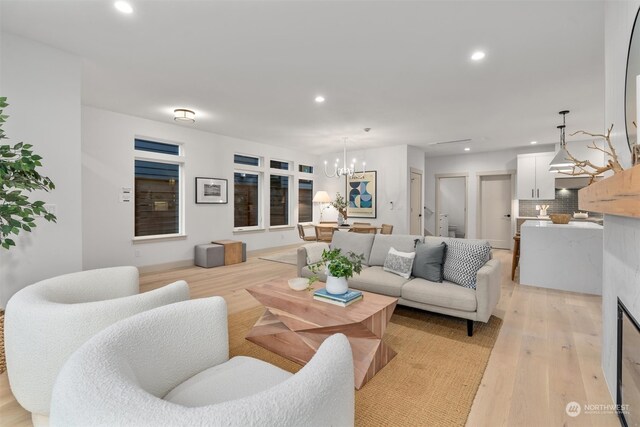 living room with a notable chandelier and light wood-type flooring