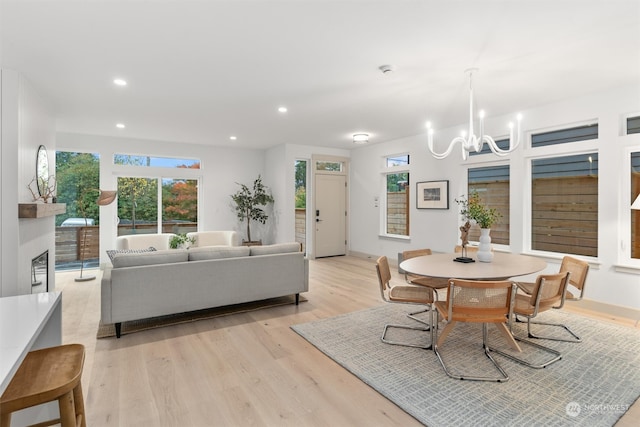 dining space with light hardwood / wood-style flooring and a notable chandelier