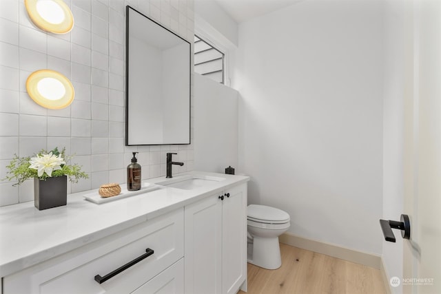 bathroom featuring vanity, toilet, backsplash, and hardwood / wood-style floors