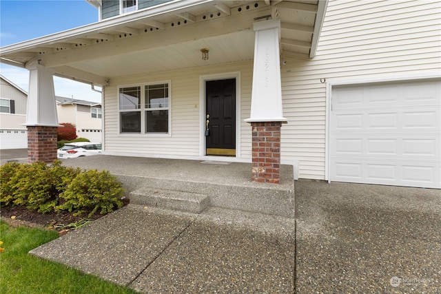 view of exterior entry featuring a porch and a garage