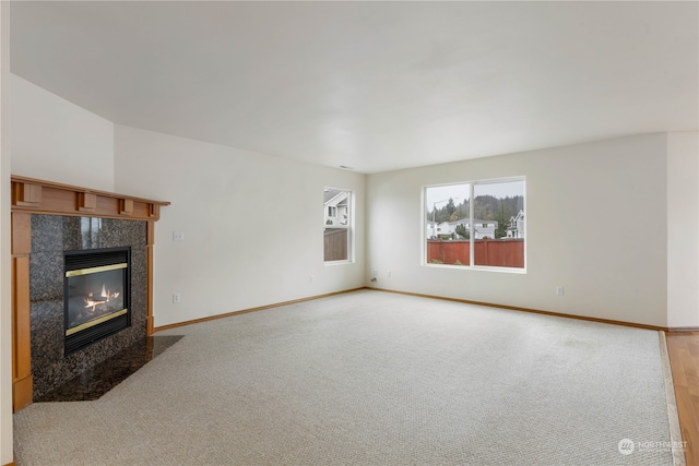 unfurnished living room featuring light carpet and a tiled fireplace