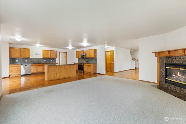 unfurnished living room featuring light hardwood / wood-style floors, sink, and a fireplace