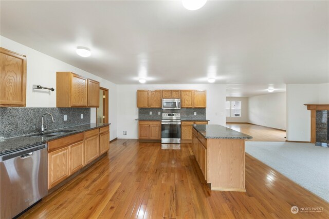 kitchen featuring appliances with stainless steel finishes, backsplash, and light hardwood / wood-style floors