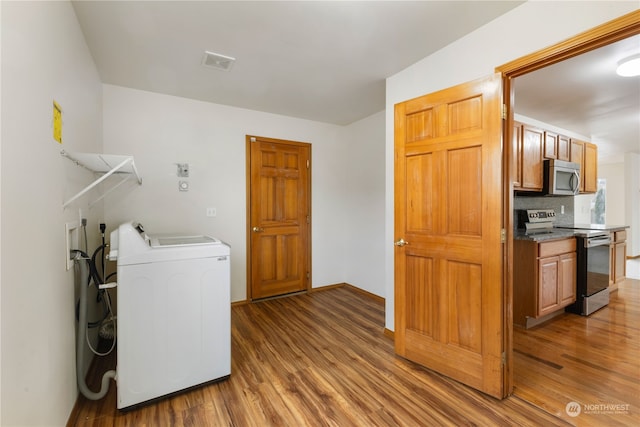 washroom with dark wood-type flooring and washer and clothes dryer