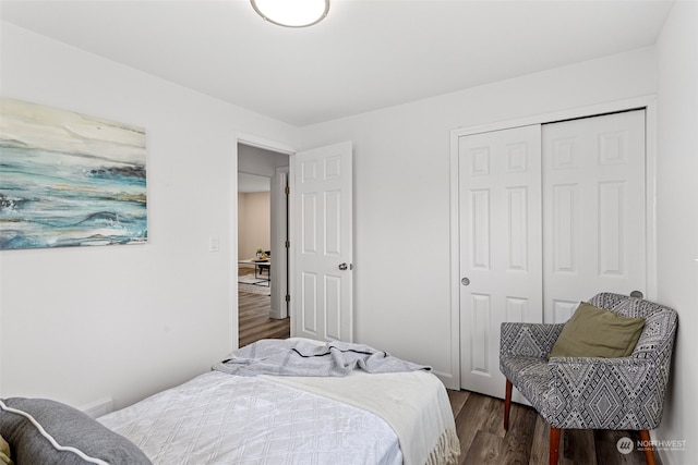 bedroom with dark wood-type flooring and a closet