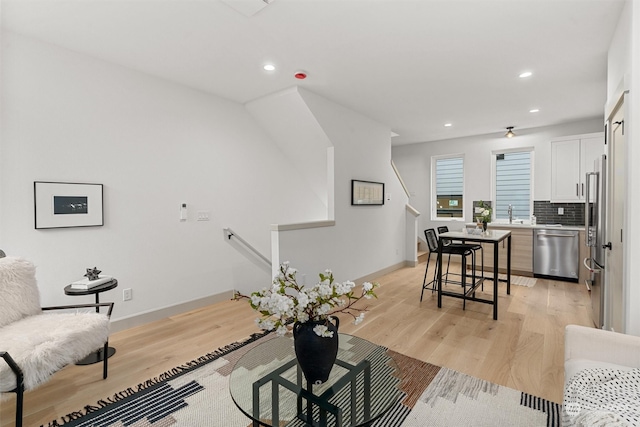 living room with light hardwood / wood-style floors and sink