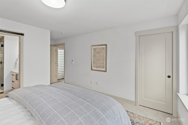 carpeted bedroom featuring a barn door