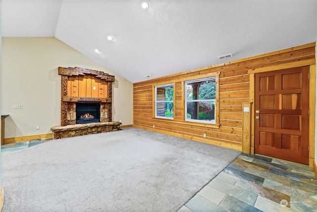 unfurnished living room with carpet flooring, vaulted ceiling, and wooden walls