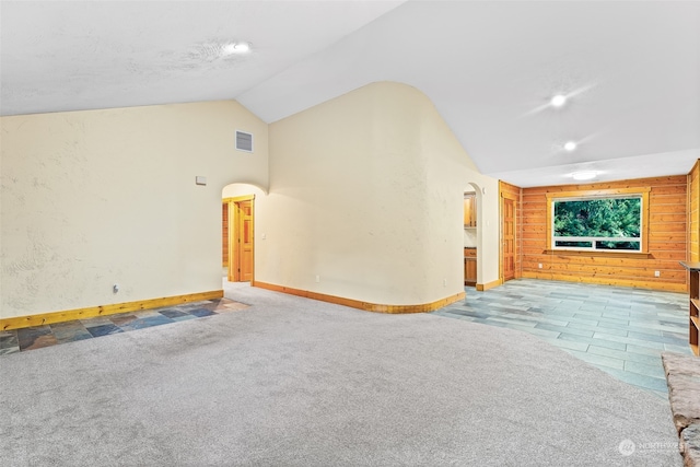 unfurnished living room featuring vaulted ceiling and light colored carpet