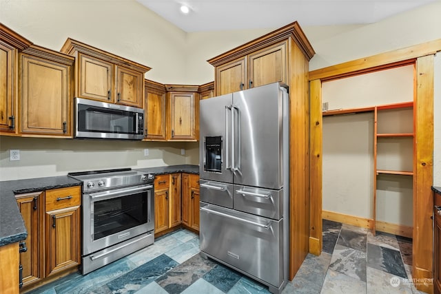 kitchen with dark stone countertops and stainless steel appliances