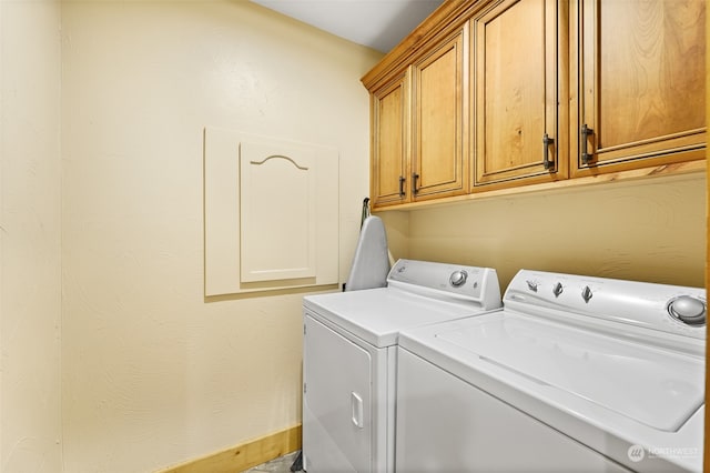 clothes washing area featuring washer and clothes dryer and cabinets