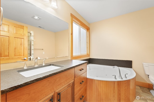 bathroom featuring vanity, a bathtub, and toilet