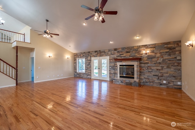 unfurnished living room with french doors, ceiling fan, high vaulted ceiling, and light wood-type flooring