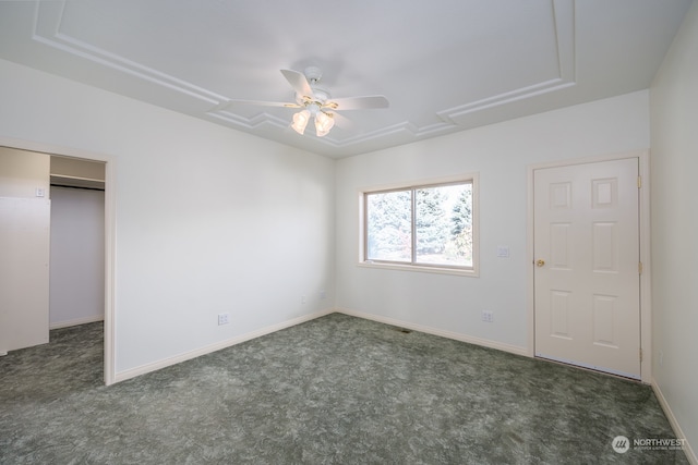 unfurnished bedroom featuring ceiling fan and dark carpet