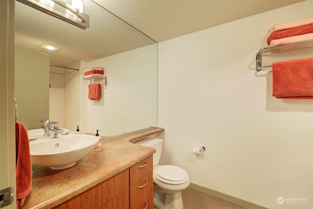 bathroom with vanity, toilet, and walk in shower