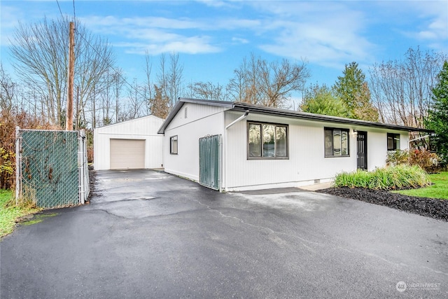 view of front of home featuring a garage and an outbuilding