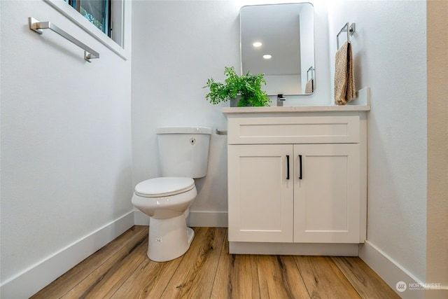 bathroom with vanity, hardwood / wood-style floors, and toilet