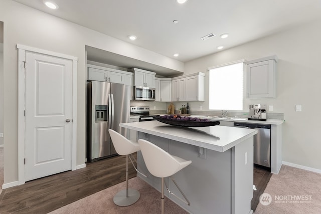 kitchen with a kitchen bar, visible vents, a kitchen island, recessed lighting, and stainless steel appliances