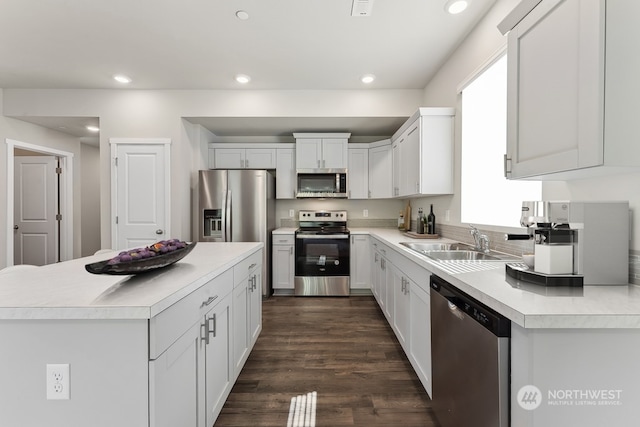 kitchen with recessed lighting, a sink, stainless steel appliances, dark wood-type flooring, and light countertops