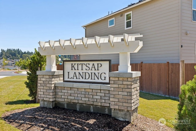 community sign featuring a lawn and fence