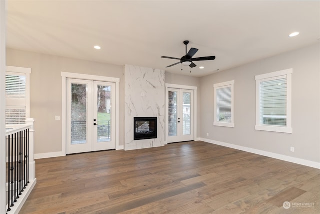 unfurnished living room featuring a fireplace, dark hardwood / wood-style floors, and ceiling fan