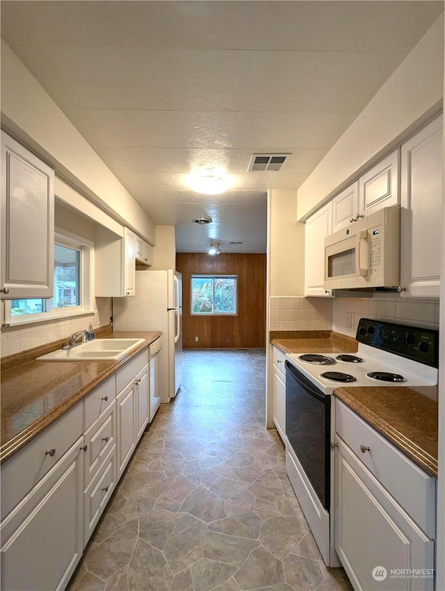930 Trosper Rd SW Unit 70, Tumwater, WA 98512 - kitchen featuring white appliances, decorative backsplash, light stone finish flooring, white cabinetry, and a sink