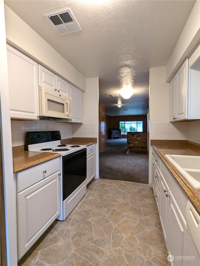 930 Trosper Rd SW Unit 70, Tumwater, WA 98512 - kitchen featuring white appliances, light colored carpet, white cabinets, tasteful backsplash, and open floor plan