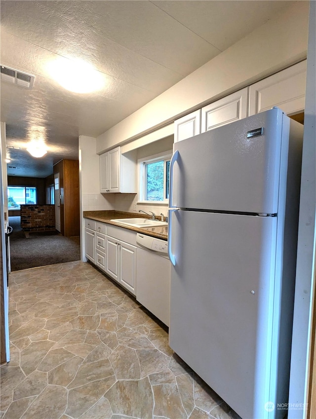 930 Trosper Rd SW Unit 70, Tumwater, WA 98512 - kitchen with white appliances, a sink, stone floors, white cabinets, and healthy amount of natural light