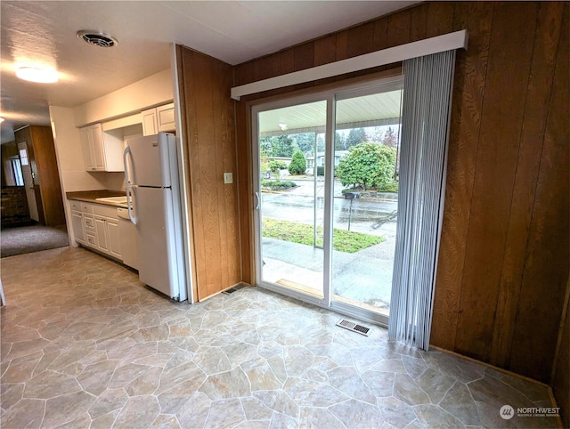 930 Trosper Rd SW Unit 70, Tumwater, WA 98512 - kitchen featuring freestanding refrigerator, stone floors, wood walls, and dark countertops