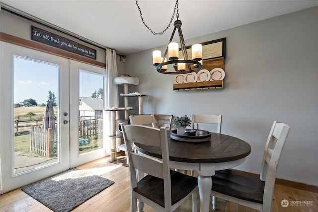 dining room featuring light hardwood / wood-style flooring, an inviting chandelier, and french doors