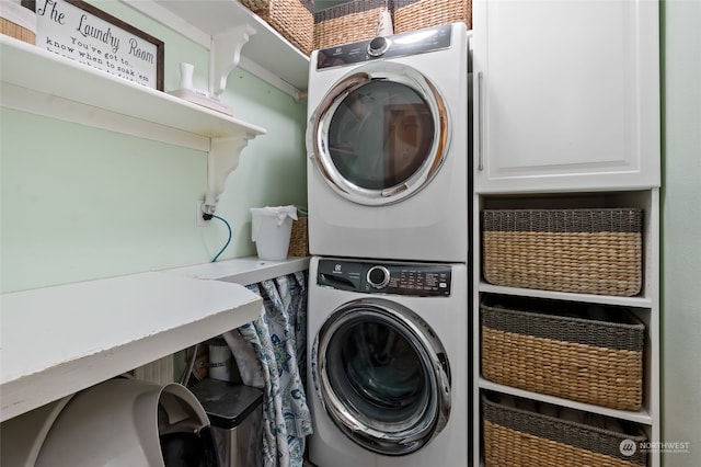 laundry room with stacked washer / drying machine and cabinets