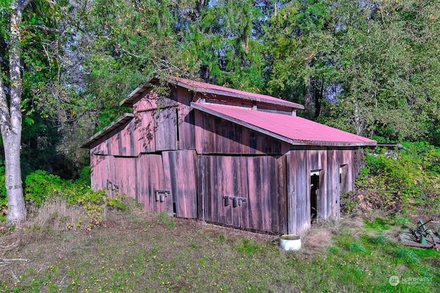 view of barn featuring a wooded view