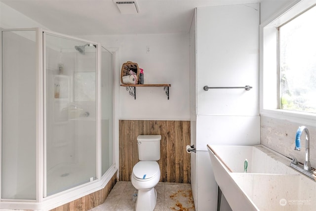 bathroom featuring a sink, toilet, visible vents, tile patterned floors, and a stall shower