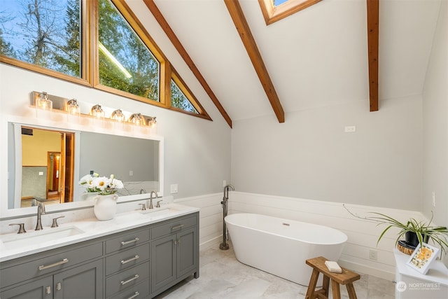 bathroom with beam ceiling, a bathtub, high vaulted ceiling, a skylight, and vanity