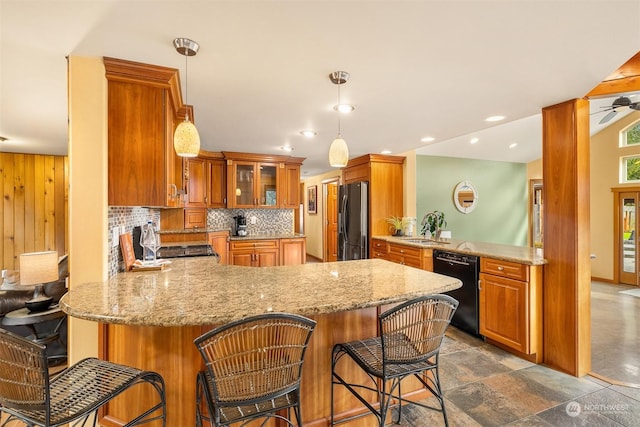 kitchen featuring a peninsula, brown cabinetry, freestanding refrigerator, dishwasher, and backsplash