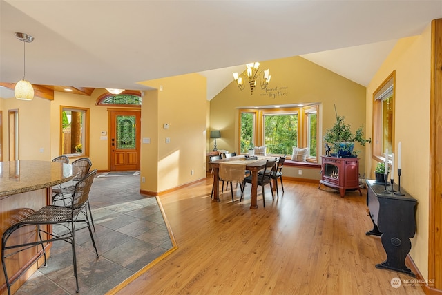 dining room featuring a notable chandelier, hardwood / wood-style flooring, and vaulted ceiling