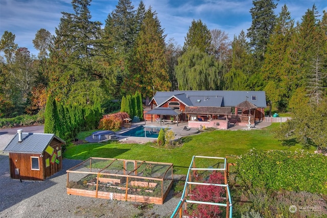 exterior space with a patio, a vegetable garden, an outbuilding, and a lawn