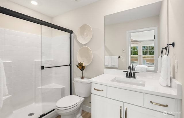 bathroom with vanity, hardwood / wood-style floors, toilet, and an enclosed shower