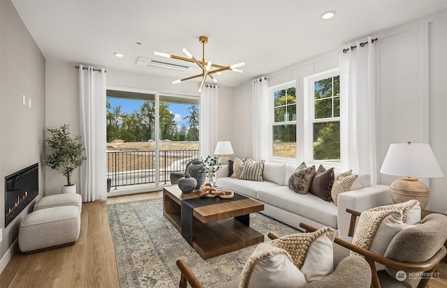 living room with a notable chandelier and light hardwood / wood-style floors