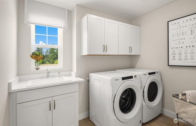 9017 NE 203rd Ct Unit A, Bothell, WA 98011 - washroom with baseboards, a sink, washing machine and clothes dryer, light wood-type flooring, and cabinet space
