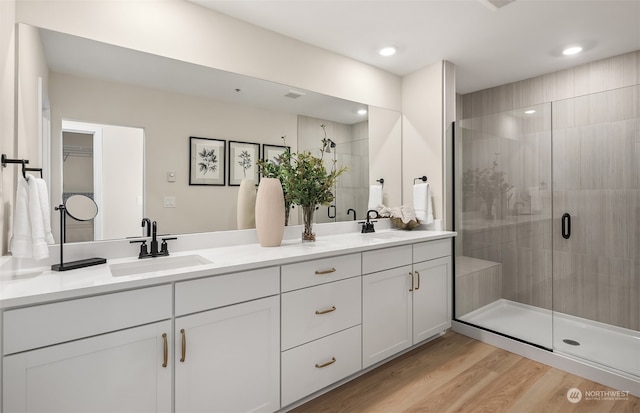 bathroom featuring a shower with door, wood-type flooring, and vanity