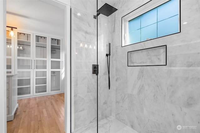 bathroom featuring tiled shower and wood-type flooring