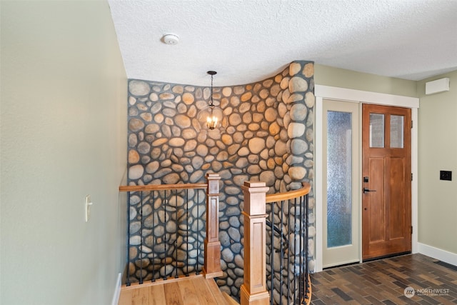 foyer entrance with a textured ceiling and dark hardwood / wood-style flooring