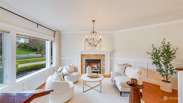 living area with plenty of natural light, ornamental molding, and a notable chandelier